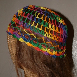 May include: A colorful crocheted hat with a rainbow pattern. The hat is made with a variety of colors, including red, orange, yellow, green, blue, and purple.