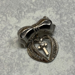 Small filigree rhinestone cross heart brooch in silver tone metal