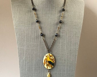 Black and yellow acrylic bird cameo necklace with black cats eye beaded chain in antique brass