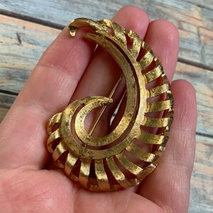 Monet brushed gold tone curled fenestrated feather brooch