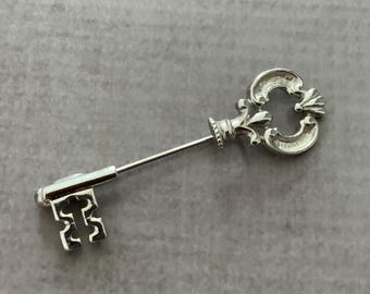 Broche vintage Avon con llave esqueleto ornamentada en tono dorado