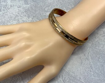 Textured striped diamond dust monet bangle in gold tone metal