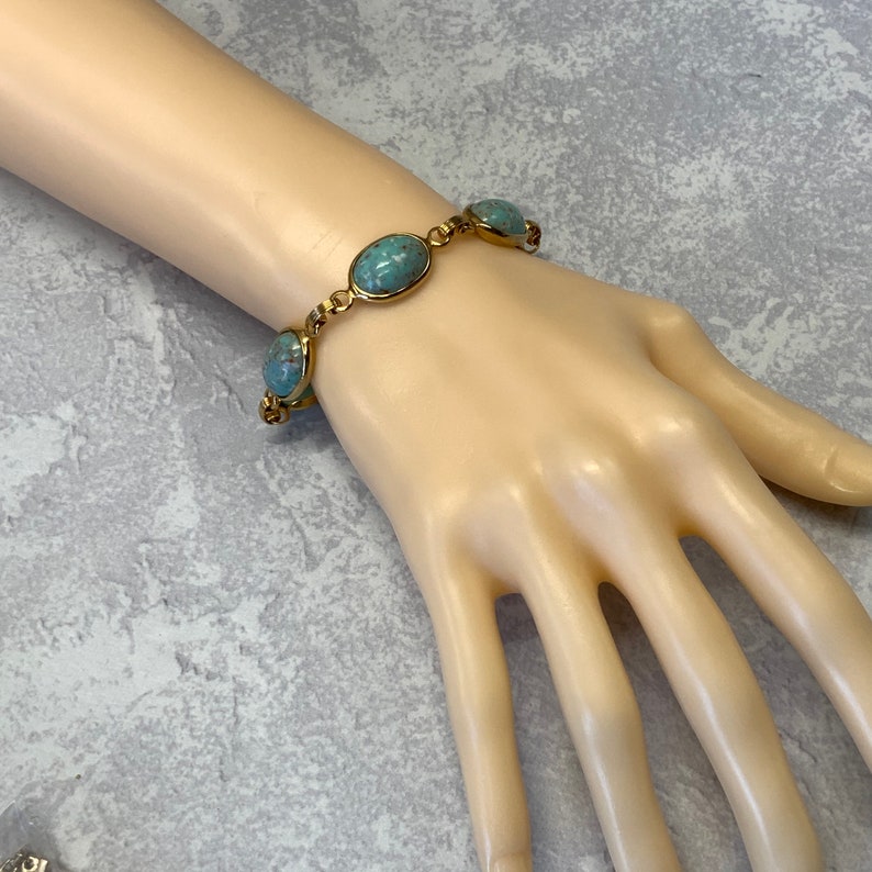 Robbins egg blue glass stone bracelet in gold tone metal