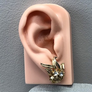 Gold tone swirling leaf rhinestone clip on earrings
