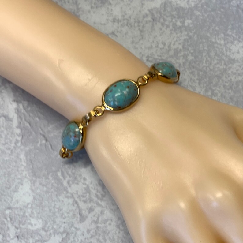 Robbins egg blue glass stone bracelet in gold tone metal