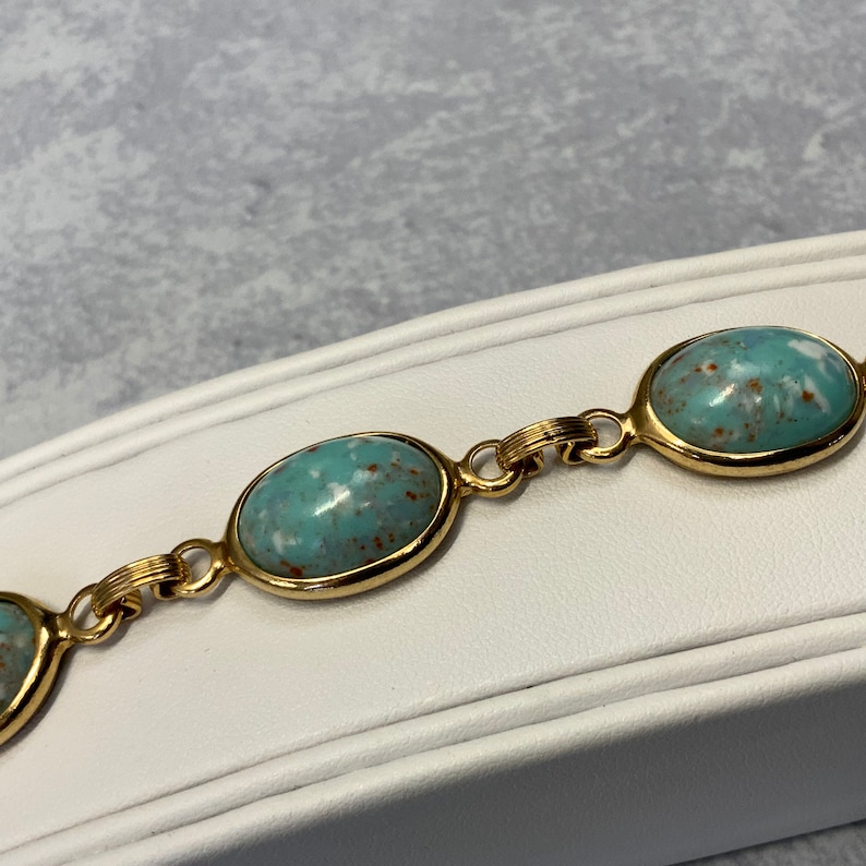 Robbins egg blue glass stone bracelet in gold tone metal