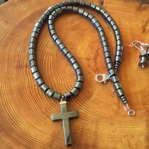 20 inches of Black Hematite cylinders support a simple Hematite Cross.  The Hematite stone symbolizes Grounding and Protection!