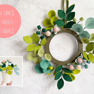 K&ouml;nnte beinhalten: Ein gr&uuml;ner Filz-Adventskranz mit rosa Filzkugeln und gr&uuml;nen Filzbl&auml;ttern. Der Kranz h&auml;ngt an einer wei&szlig;en Wand. Der Text "WITH LINKS TO VIDEO TUTORIALS" ist in einem rosa Kreis auf der linken Seite des Bildes geschrieben.