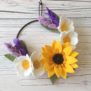 Può includere: Una ghirlanda di feltro con un girasole, fiori bianchi e lavanda viola. La ghirlanda è realizzata in feltro ed è un ottimo modo per aggiungere un tocco di primavera alla tua casa.