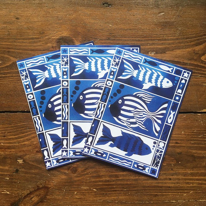 May include: Three blue and white patterned cards with a fish design. The cards are stacked on top of each other. The fish are stylized and have a geometric pattern.