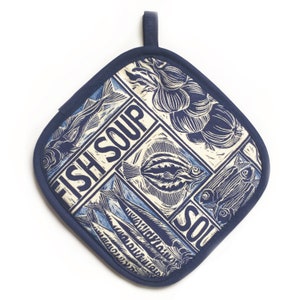 Puede incluir: Un salvamanteles azul marino y crema con un diseño acolchado. El diseño presenta ilustraciones de pescado y cebolla, con las palabras "FISH SOUP" impresas en negrita. Se adjunta un lazo azul marino para colgar.