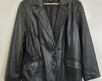 May include: Black leather blazer with a notched collar, two-button closure, and two front pockets. The Alfani brand label is visible on the inside. The jacket is hanging on a wooden hanger.