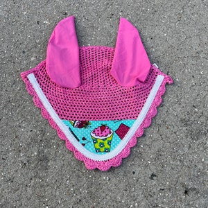 May include: Pink horse fly bonnet with white crocheted trim and a cupcake print lining.