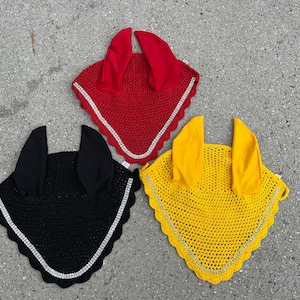 May include: Three horse fly hoods in red, black, and yellow with a sparkly trim.