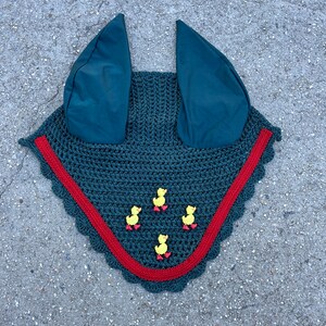 May include: A dark green horse fly bonnet with red trim and yellow rubber duck decorations.