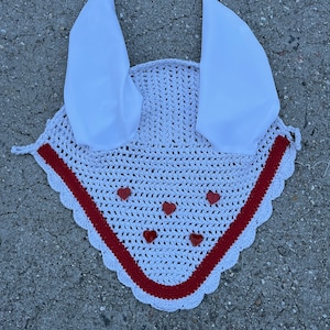 May include: White crochet horse fly bonnet with red trim and red heart embellishments. The bonnet has two white fabric ear covers.