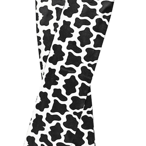 May include: Pair of black and white cow print knee-high socks with a pink trim. The socks have the brand name "Lettia Collection" on the top.