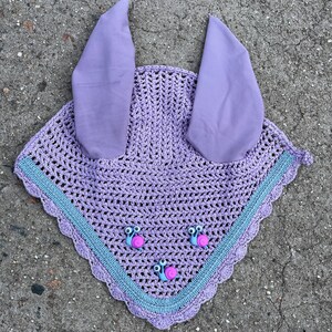 May include: A lavender crochet horse fly bonnet with a scalloped edge and three purple snail buttons. The bonnet has two lavender fabric ear covers.