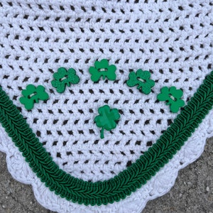 May include: White crochet horse fly bonnet with green shamrock buttons and green braid trim.