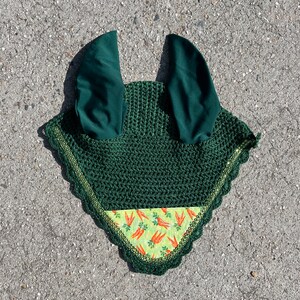 May include: Green crochet horse fly mask with a carrot print lining. The mask has two ear covers.