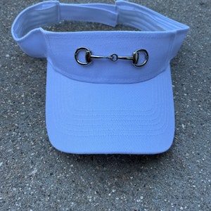May include: White visor with a silver horse bit detail.