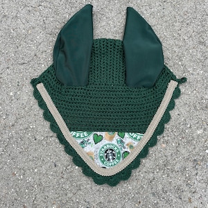 May include: Green crochet horse fly mask with ear covers and a gold trim. The trim features a scalloped edge. The mask has a Starbucks coffee themed lining.