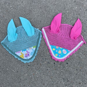 May include: Two horse fly bonnets, one blue and one pink, with a white trim and a colorful Easter egg pattern.