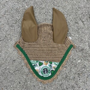 May include: A brown crochet horse fly bonnet with green trim and a Starbucks coffee themed fabric lining. The bonnet has two brown ear covers.