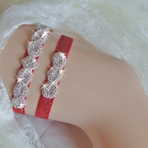 May include: Red garter with a sparkly silver design. The garter is made of a soft, stretchy material and has a delicate lace trim.