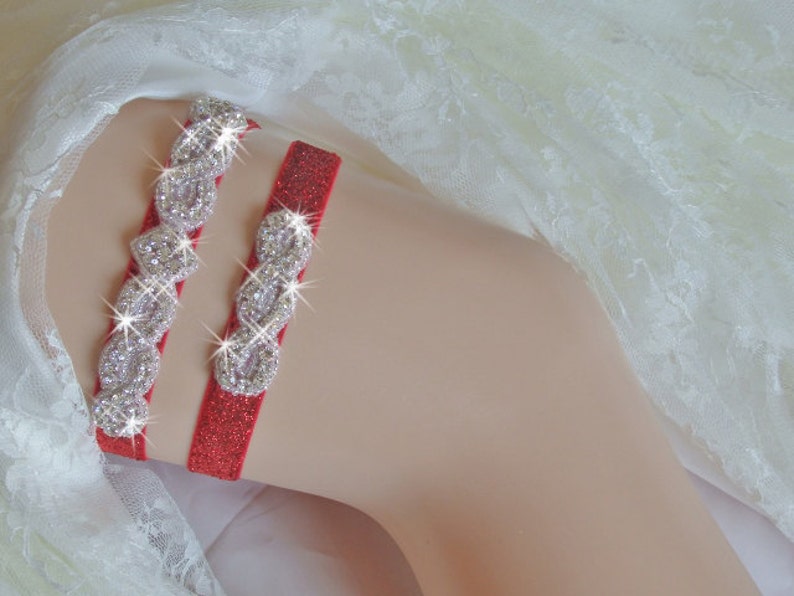 May include: Red garter with a sparkly silver design. The garter is made of a soft, stretchy material and has a delicate lace trim.