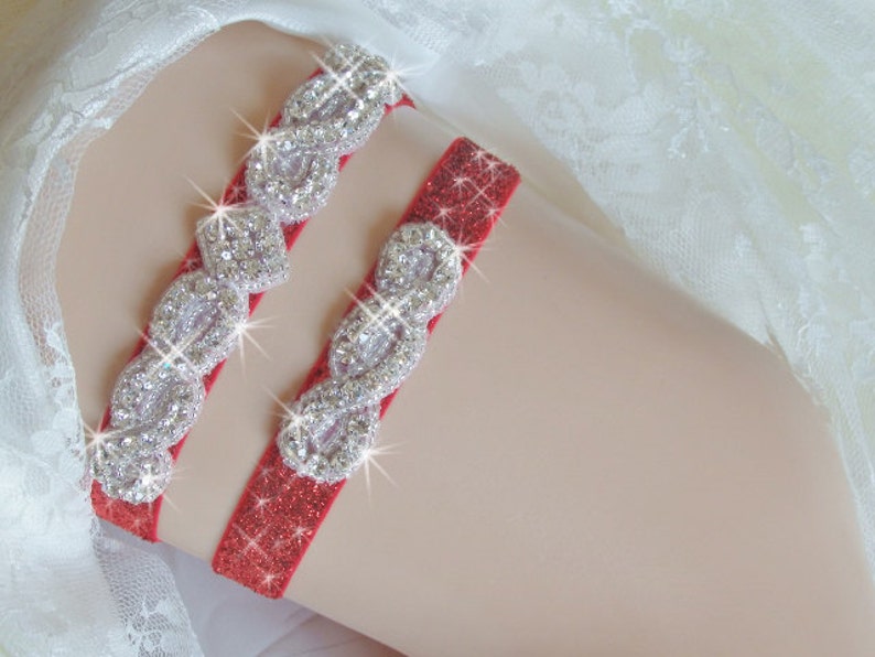 May include: Red garter with a sparkly silver design. The garter is made of a soft, stretchy material and has a delicate lace trim.
