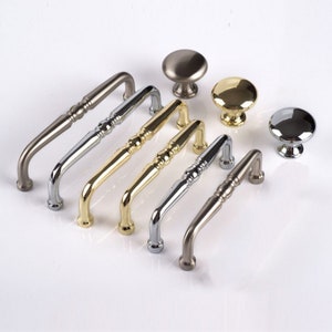 Op de afbeelding: Assortiment van kastbeslag in verschillende afwerkingen, waaronder geborsteld nikkel, gepolijst messing en chroom. Het beslag omvat zowel knoppen als handgrepen.