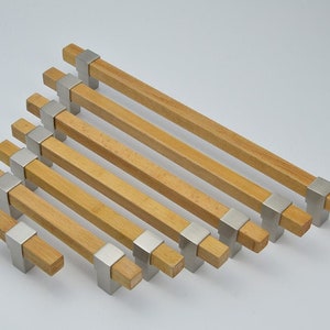 May include: A set of seven wooden cabinet pulls with brushed nickel accents. The pulls are different lengths, ranging from small to large.