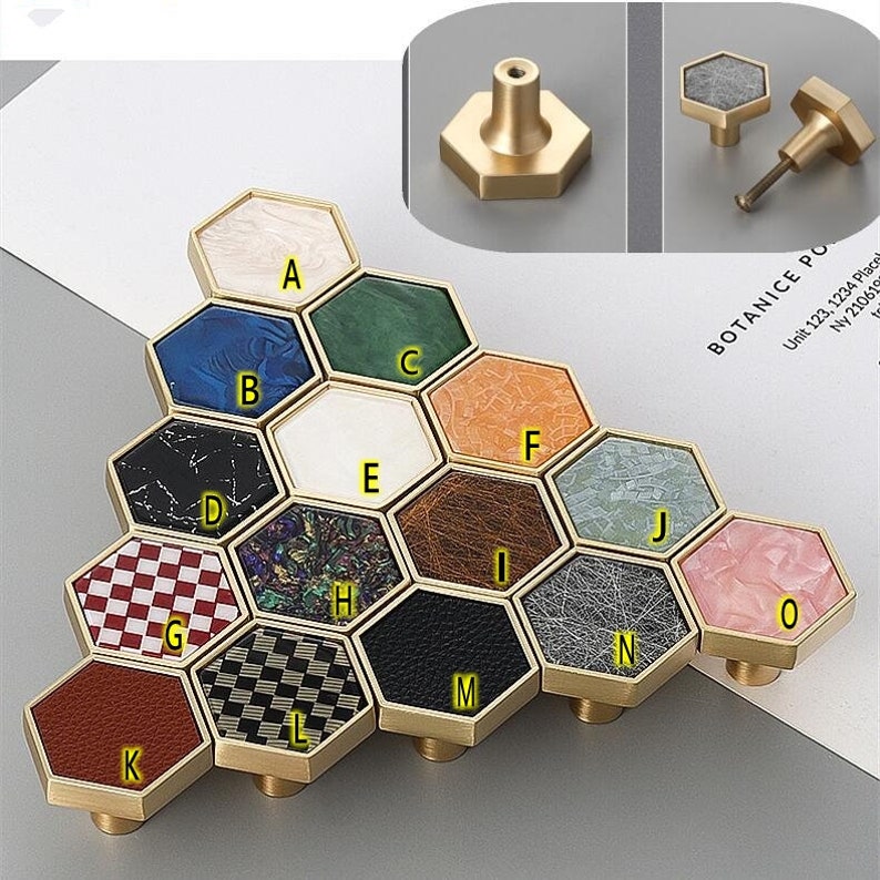 Pu&ograve; includere: Un set di 12 pomelli esagonali per armadio con diversi inserti a motivi. I pomelli sono in ottone e hanno una finitura lucida. Gli inserti presentano diversi materiali, tra cui marmo, legno e pelle.