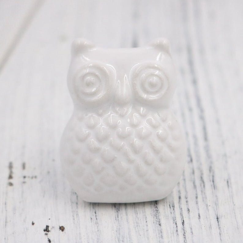 May include: White ceramic owl door knob with a textured surface.