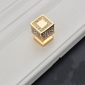 May include: Gold square cabinet knob with clear crystal rhinestones.