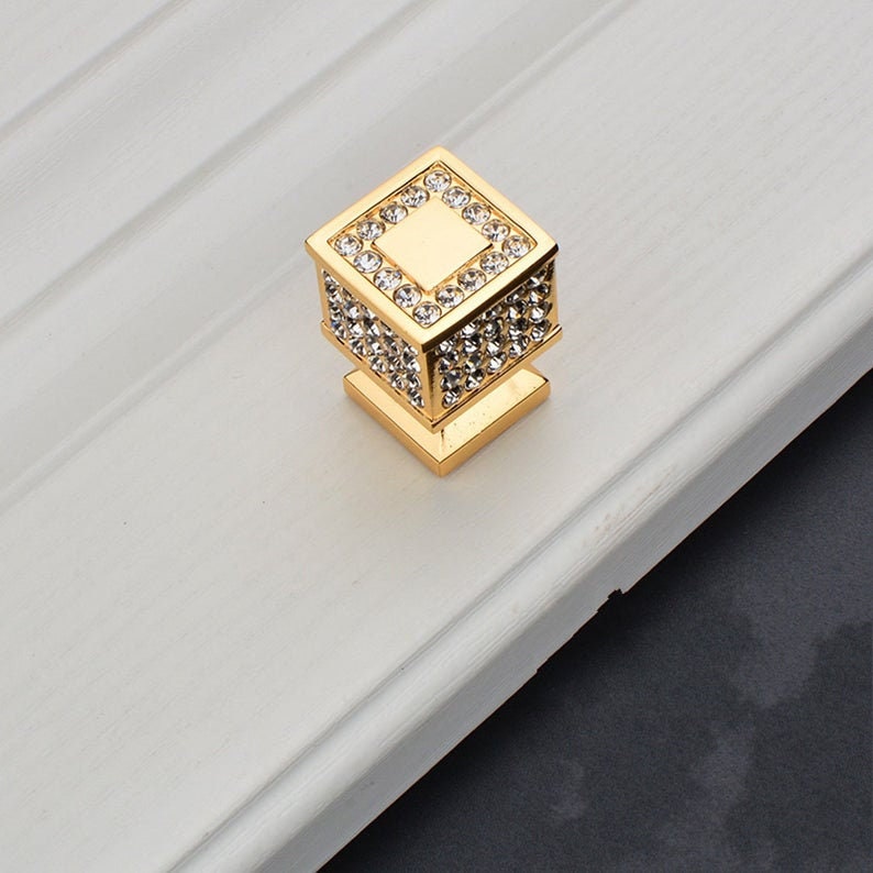 May include: Gold square cabinet knob with clear crystal rhinestones.