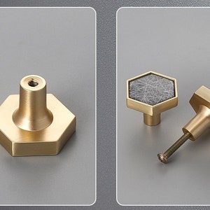 Pu&ograve; includere: Due pomelli esagonali per armadio dorati. Un pomello ha un designo in marmo grigio, l'altro &egrave; in oro massiccio.