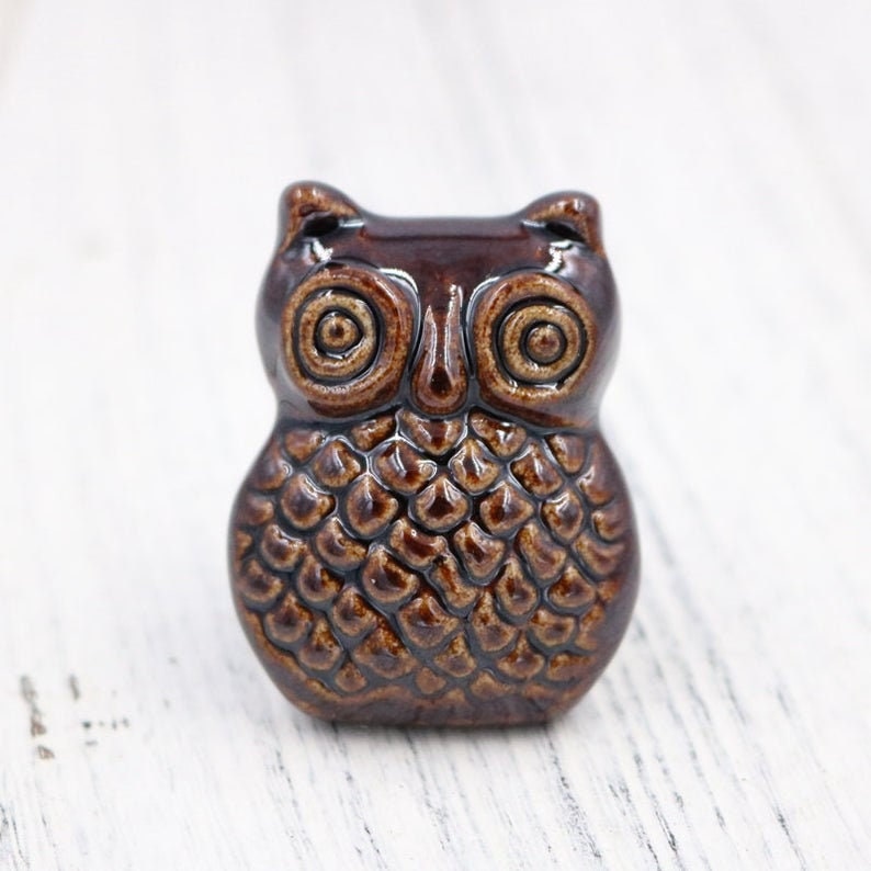 May include: A brown ceramic owl figurine with a textured surface and detailed eyes. The owl is a popular decorative item for homes and gardens.