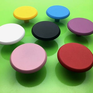 Pode incluir: Conjunto de oito botões redondos para armário em várias cores, incluindo amarelo, azul, branco, preto, rosa e vermelho.