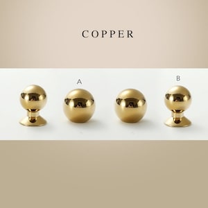 May include: Three round, gold-colored cabinet knobs with a shiny finish. The knobs are labeled A and B. The text "COPPER" is at the top of the image.