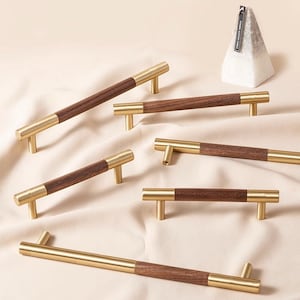 Peut inclure: Assortiment de six poignées de porte avec une finition en bois de noyer et or. Les poignées sont de styles variés, notamment une poignée de barre, une poignée en T et un bouton.