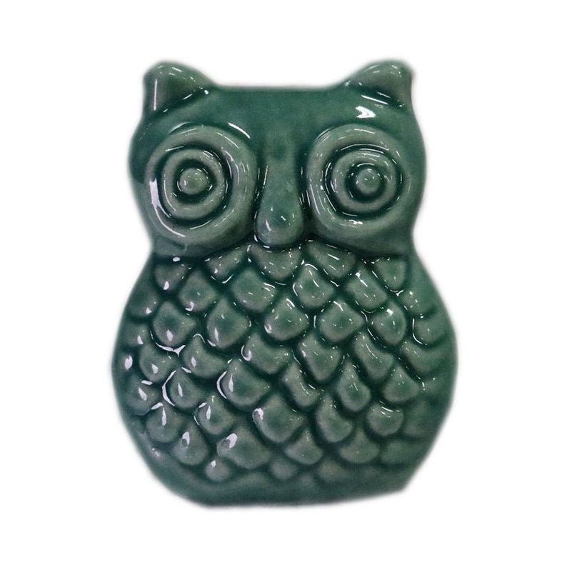 May include: A teal ceramic owl figurine with a textured, scaly body and large, round eyes.