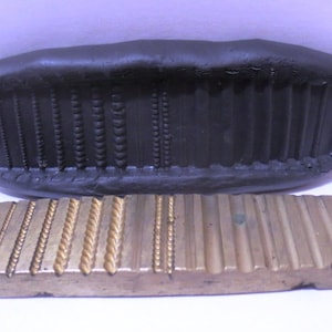 Peut inclure: Un tampon en caoutchouc noir avec une variété de motifs décoratifs, et un tampon en laiton avec les mêmes motifs.