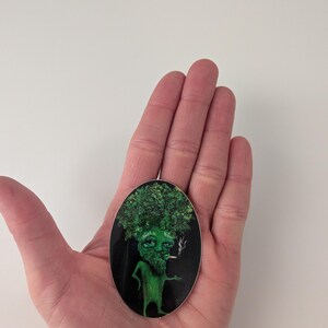 Puede incluir: Pegatina ovalada que presenta un personaje de br&oacute;coli verde antropom&oacute;rfico con barba y cigarrillo. El br&oacute;coli tiene una cabeza frondosa y est&aacute; sobre un fondo negro.