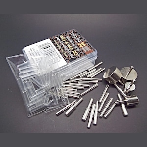 May include: A WigJig WIG-A-MA-JIG set of 30 assorted metal pegs in a clear plastic storage box, including a small plastic bag of clear cylindrical sleeves and several silver-toned metal pegs with flat circular heads and cylindrical shafts.