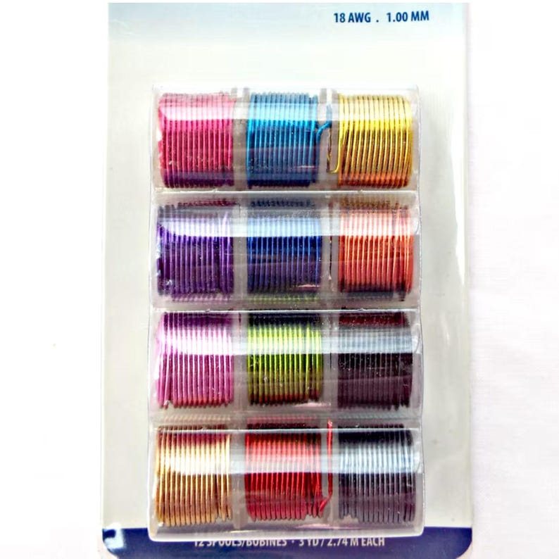 Transparent plastic pack holding 12 small plastic reels.  Each reel has a different colour of aluminium wire coiled around it.  Colours include pinks, blues, yellow, purple, green, red, grey, peach.  The package is on a white background.
