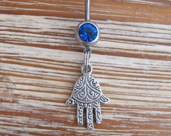 May include: A silver belly button ring with a blue gem and a hamsa hand charm.