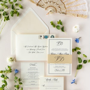 Invitación de boda atemporal en tipografía negra con diseño moderno y formal en marfil con inserto de detalles y banda con monograma dorado (otros colores)