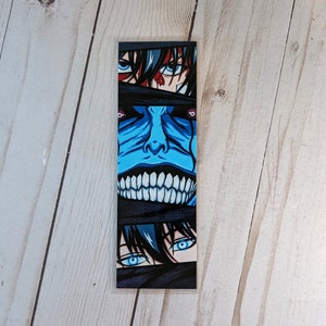 Puede incluir: Marcapáginas rectangular con ilustraciones de estilo anime. El diseño incluye una cara azul con una amplia sonrisa y ojos que asoman de vendas negras. Las secciones superior e inferior muestran ojos con iris azules.